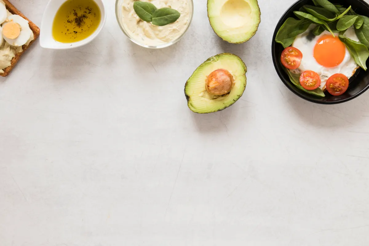 بيض مقلي في مقلاة مع شرائح أفوكادو وطماطم، مثال على فطور كيتو